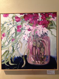 a painting of pink flowers in a glass jar on a wall above a sign that reads,