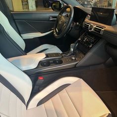 the interior of a car with white leather and black trims, including steering wheel