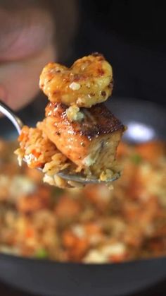 a person is spooning food out of a pan with some kind of meat on it