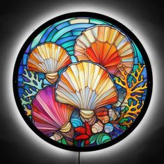 a circular stained glass window with shells and corals in the center on a black background