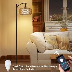 a person holding a smart phone in front of a living room with a couch and lamp