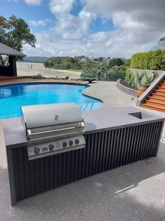 an outdoor grill next to a swimming pool