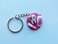 a pink key chain with a toothbrush on it and a wooden ring around it