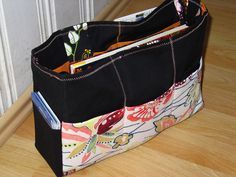 a black bag sitting on top of a wooden floor next to a door with an open book in it