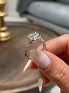 a close up of a person holding a diamond ring