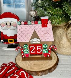 a gingerbread house with santa clause and candy canes next to it on a table