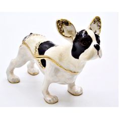 a small figurine of a dog wearing a harness and gold trimmings