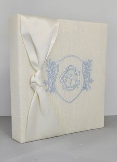 a white box with a blue design on the side and a bow at the top