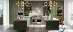 a kitchen with green cabinets and an island in front of the stove, oven and microwave