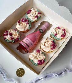 cupcakes with frosting and pink wine in a box