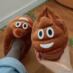 someone is holding up two brown slippers with googly eyes