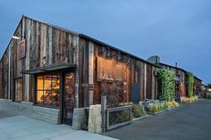 an old building is lit up at night with the lights on and ivy growing all over it