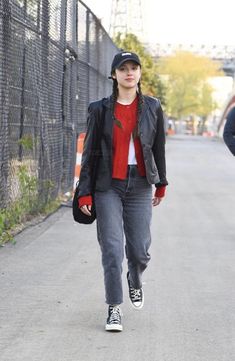 a woman walking down the street with her hand in her pocket