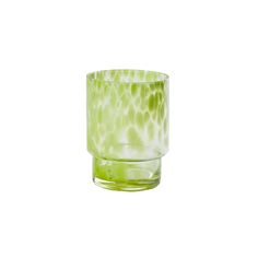 a green glass sitting on top of a white surface