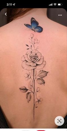 the back of a woman's neck with flowers and a butterfly on it