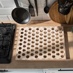 a stove top oven sitting next to a wooden table with utensils on it