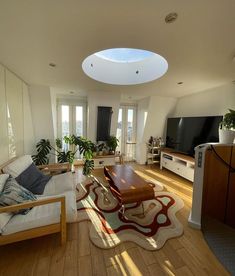 a living room filled with furniture and a flat screen tv on top of a hard wood floor