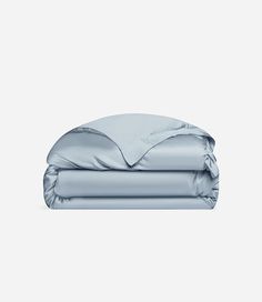 an unmade bed with blue sheets and pillows on top of it, in front of a white background