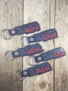 four keychains with the words banh bah on them sitting on a wooden surface