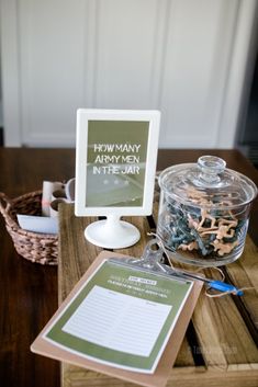 a wooden table topped with a glass jar filled with magnets next to a sign