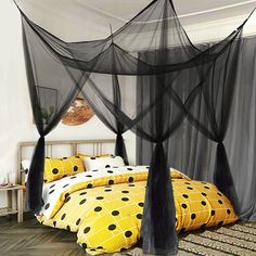 a bed with black netting over it and polka dots on the comforter, along with pillows