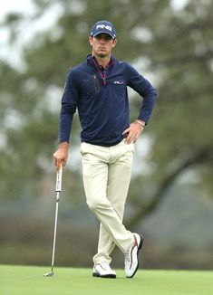 a man walking across a green holding a golf club