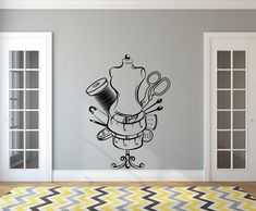 a wall decal with scissors and other things on it in the corner of a room