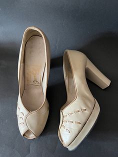 The 1970s were so good at doing the 1930s and 1940s and these shoes are a perfect example.  They are made in England by Ravel.  They are a great version of 40s peeptoe platforms.  They are made in pale beige with a darker beige trim and stitch detail.  They have a wrapover effect at the front.  They slip on.  The heel is enclosed.  The platform is 0.5 inches tall and the heel is 4 inches (10cm) tall. I am not sure if the uppers are leather or not.  The interior is not.  Nor is the platform, heel Beige Trim, Pale Beige, Platform Shoes Heels, Dark Beige, Pumps Shoes, Platform Heel, Packing Material, Heels Shoes, The Platform