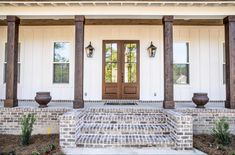 the front door of a house with two large planters