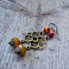 This series has a lot of beautiful orange, yellow, and red Czech glass beads. There are several items in the series that will all mix and match. Be sure to click on the link below. This listing is for these long dangle earrings with beautiful yellow orange beads. The bottom bead is 12 x 10mm with a Picasso finish. The top bead is a mix of glass and each bead is slightly different. Every bead is unique and beautiful. These are offered with antique brass findings and your choice of brass or titani Handmade Orange Brass Earrings, Bohemian Orange Czech Glass Earrings, Unique Orange Earrings With Dangling Beads, Orange Czech Glass Dangle Earrings, Amber Brass Earrings For Gift, Orange Metal Earrings As Gift, Orange Metal Earrings As A Gift, Vintage Orange Earrings With Czech Glass, Vintage Orange Czech Glass Earrings