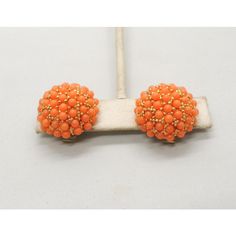 This is part of Chairish’s Costume Jewelry assortment.  1960s round goldtone pave cabochon pale orange faux-coral studded domed clip earrings. Marked "Hobe." Measure: 7/8 inches across by 1/2 inch deep. Condition: Very good; some yellowing to plastic rollers on the backs normal for their age. Elegant Orange Clip-on Earrings, Vintage Orange Round Earrings, Orange Clip-on Earrings For Formal Occasions, Formal Orange Clip-on Earrings, 50s Costume, Pale Orange, Coral Beads, Clip Earrings, Vintage 1960s