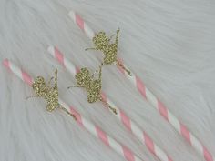 two pink and white striped straws with gold glitter butterflies