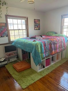 a bed sitting on top of a wooden floor in a bedroom next to a window