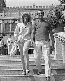 a man and woman walking down some steps