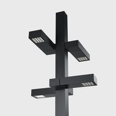 three square lights are attached to a metal pole in the shape of an inverted cross