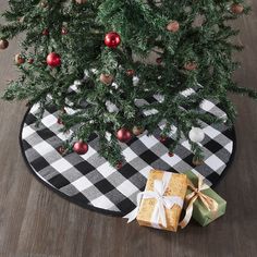 a black and white checkered tablecloth with presents under a christmas tree on it