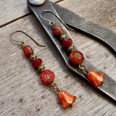 Perfect for fall! The beads on these earrings are all Czech glass beads. They are a mix of oranges. They are shown with antique brass beads and titanium ear wire, but are also available in copper. The bottom bead is 10mm, rustic orange tulip shaped bead. The top bead is a tri-cut orange bead, with a Picasso finish. There is a touch of terra cotta and clear dark red (almost Burgundy) in the 4x7mm bead in the middle. My favorite bead on these is the red orange flower bead. It is an 8mm premium Cze Orange Teardrop Earrings With Dangling Beads, Unique Orange Jewelry With Dangling Beads, Vintage Orange Earrings With Czech Glass, Unique Orange Earrings With Dangling Beads, Orange Faceted Beads Dangle Earrings, Cut Orange, Rustic Orange, Dangle Earrings Boho, Homemade Stuff