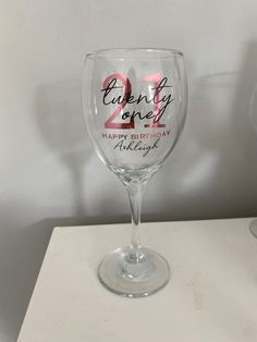 a wine glass that says twenty one happy birthday with pink and black lettering on it