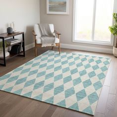 a blue and white rug in a living room with a chair next to a window