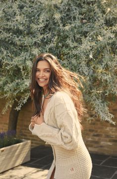 a woman is smiling while walking down the street