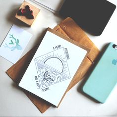 an apple phone sitting on top of a table next to some cards and envelopes