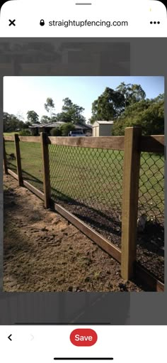 a fence that is in the dirt near some grass and trees with a house in the background