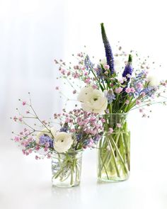 two vases filled with white and purple flowers