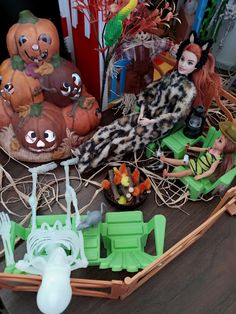 several halloween figurines are sitting on a table with pumpkins and other decorations