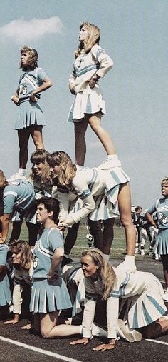 a group of cheerleaders standing on top of each other in the middle of a road