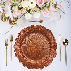 a table setting with flowers and goldware