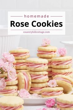 some cookies with pink icing and flowers on them are stacked up in front of the camera