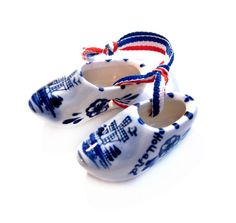 blue and white baby shoes with red, white, and blue designs on them sitting on a white surface