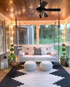 a porch with white furniture and lights on the ceiling