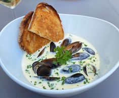 a white bowl filled with clams and bread